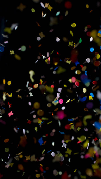 istock Multicolored paper ribbons, free falling confetti on a black background 2237539872