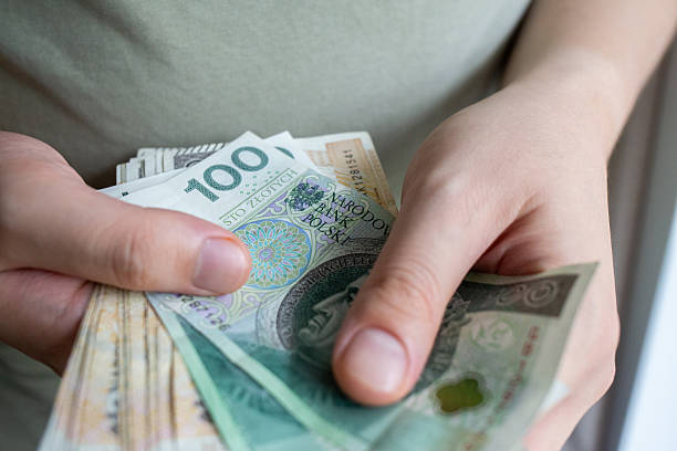istock Person holding stack of Polish zoty banknotes 2237540352