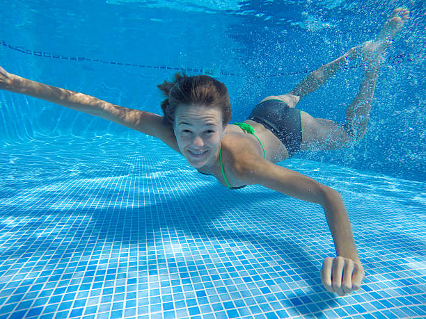 istock Happy smiling young woman under the water, while looking at camera. 2237542303