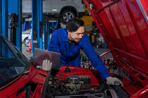 istock garage services concept,modern auto mechanic man in uniform using laptop diagnostic check a car and fixing in service station 2237550277