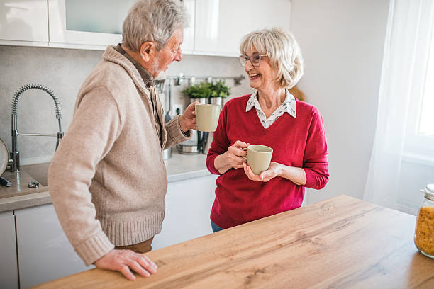 istock Smiling senior couple sipping coffee while chatting in a cozy home kitchen 2237554608