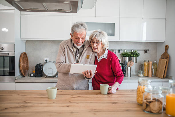 istock Carefree senior couple drinking coffee and browsing recipes on digital tablet 2237555970