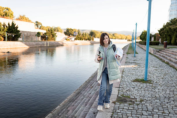 istock Female Traveler Exploring Outdoors with Backpack and Map by River 2237555993