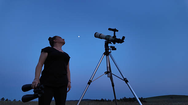 istock Amateur astronomer using telescope and binoculars for watching stars, Moon, planets and other celestial objects from a field in nature. 2237556558