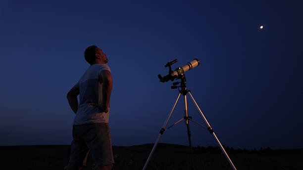 istock Amateur astronomer using telescope for watching stars, Moon, planets and other celestial objects from a field in nature. 2237556579