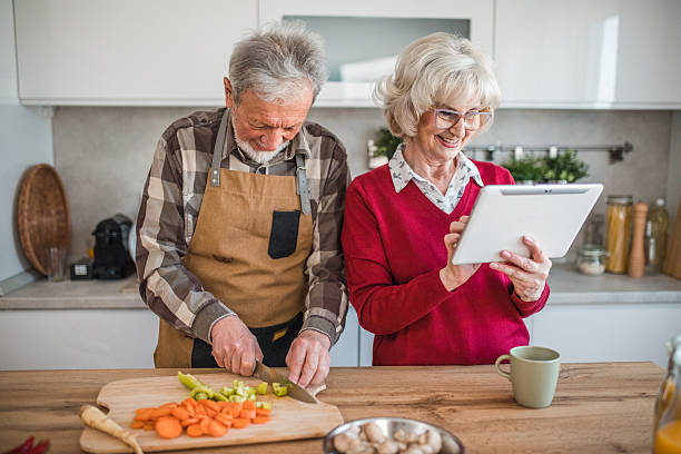 istock Senior man prepping vegetables while wife reads recipe on digital tablet 2237558779