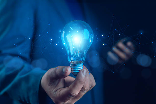 istock Businessman holding glowing blue light bulb with digital network, symbolizing innovation, technology, creativity, big data, intelligence, smart ideas, energy solutions, and future business vision. 2237558785
