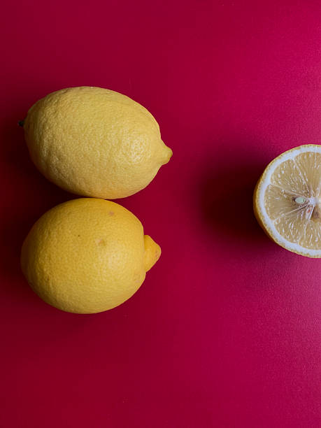 istock Fresh lemon pattern on a vivid pink background. Flat lay. Lemons. Vitamin C. Creative minimal art. Minimal summer concept. Whole and halved lemon on a pink background with copy space for text. 2237559320