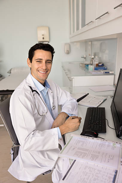 istock Happy handsome Latin practitioner man filling paper forms 2237559986