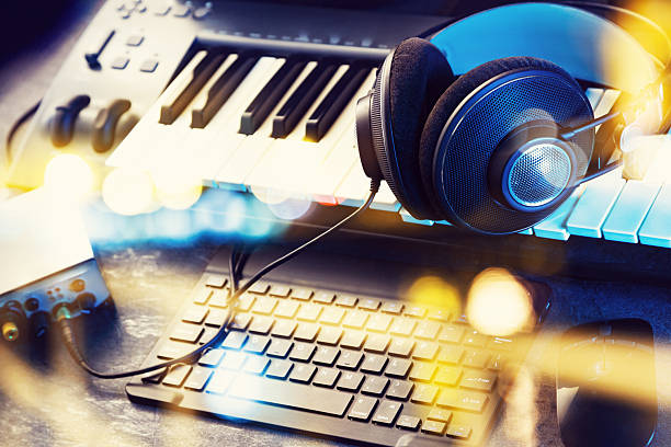 Keyboard or synthesizer with headphones and sound card. Computer recording and music production concept.