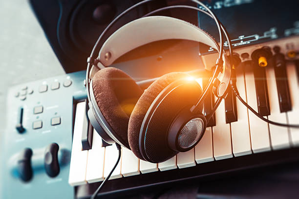 Full-sized headphones on a piano keyboard, close up shot. Abstract music background.