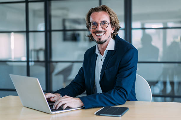 istock Successful businessman in modern office working on laptop. 2237568329