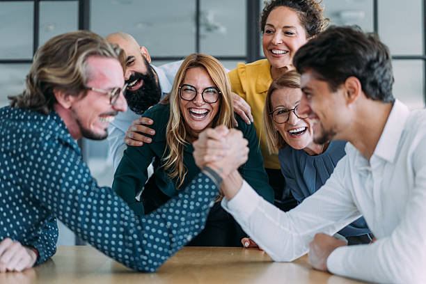 istock Cheerful creative colleagues having fun while arm wrestling in the office. 2237568333