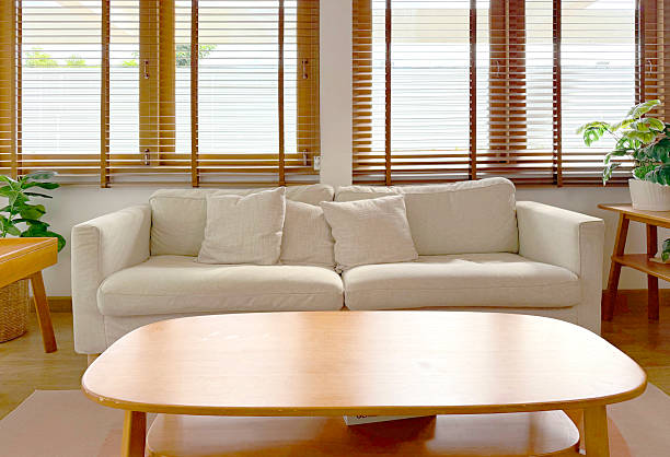 istock Bright, modern living room interior with a comfortable beige sofa, plush pillows, and a sleek oval wooden coffee table. A Scandinavian-inspired decor with green houseplants. 2237569882