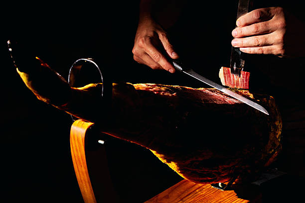 Close-up detail of master Iberian ham cutter on dark background.