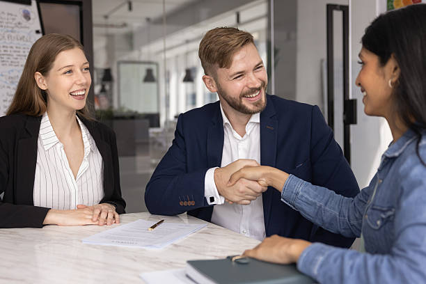 istock Happy diverse business partners shaking hands at office table 2237570839