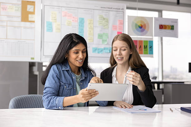 istock Happy young diverse female coworkers watching work content on tablet 2237571208