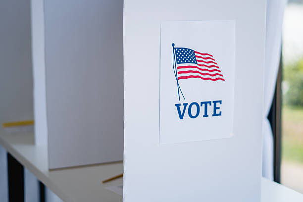 istock American flag and vote sign in voting booth 2237574290