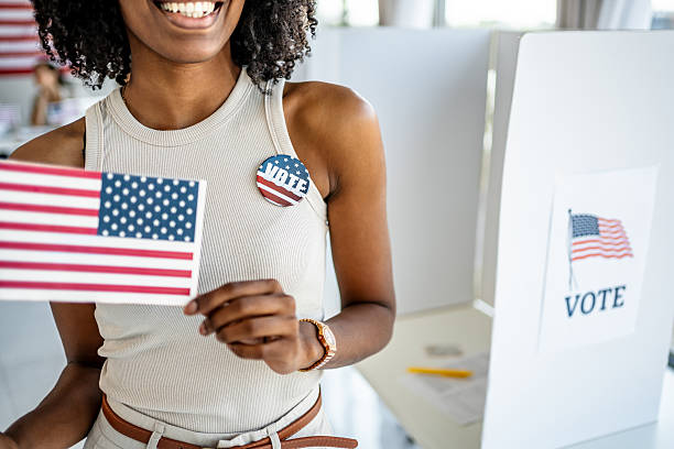 istock Woman holding American flag at voting booth 2237575049