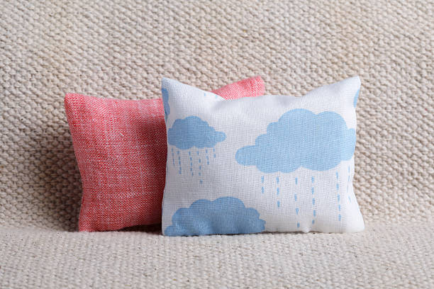 Cushion with clouds and pink cushion on sofa