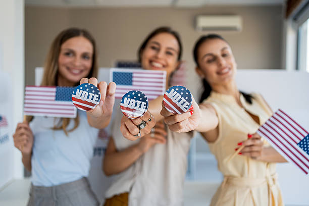 istock Three women showing vote buttons and American flags 2237578227