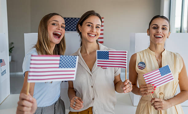 istock Women holding American flags at polling place 2237578234