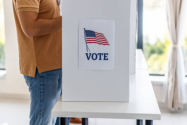 istock Person standing in voting booth making important election choice 2237578557