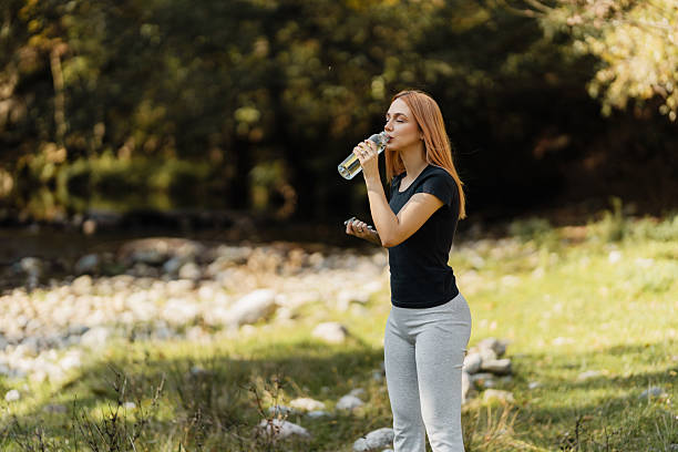 istock Woman drinking water in nature during hike 2237578860