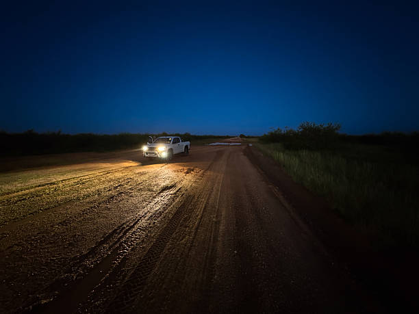 istock Pick up truck on a dirt road at night 2237579904