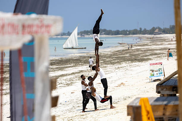 Tanzania, Zanzibar-September 15,2025: Local performers dance for beach visitors on the shores of Zanzibar, Tanzania. The scene shows traditional movements and vibrant coastal culture as tourists watch and engage with the activity. Captured for editorial use only, highlighting cultural interactions and everyday moments on the island’s popular beaches.