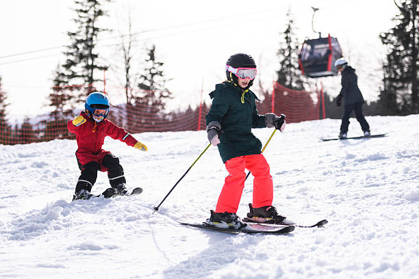 istock Children skiing downhill on sunny winter day 2237584810