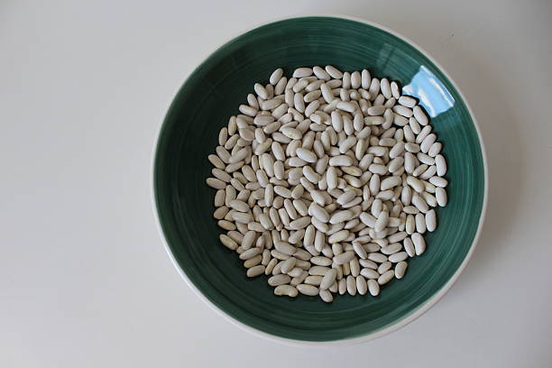 istock Horizontal photo.Young, raw white beans in a ceramic bowl. Isolated on a white background. Flat lay. Copy space on the left. 2237585775