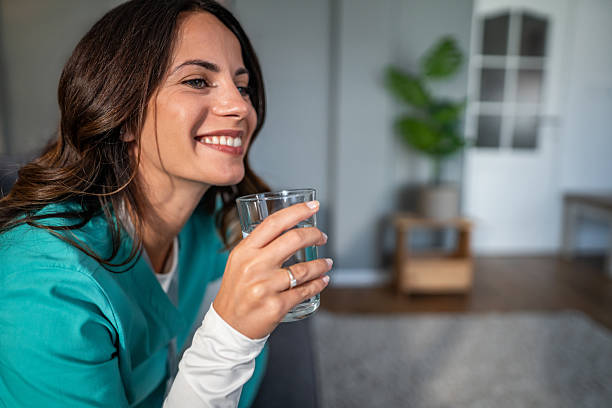 istock Smiling nurse drinking water enjoying a break at home 2237589906