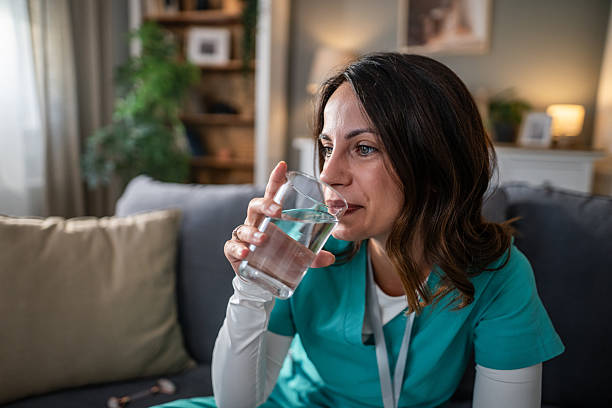 istock Healthcare worker drinking water relaxing on sofa 2237589919