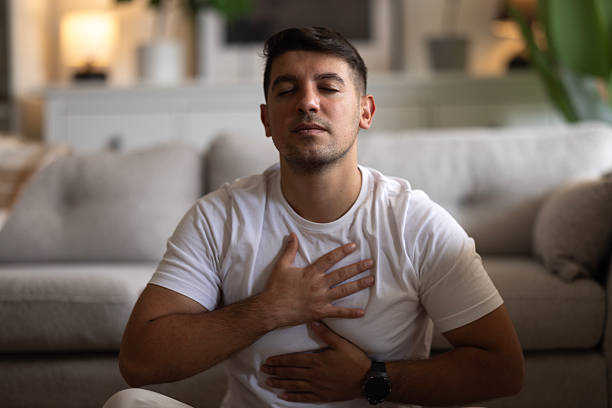 istock Young man meditating at home 2237594106