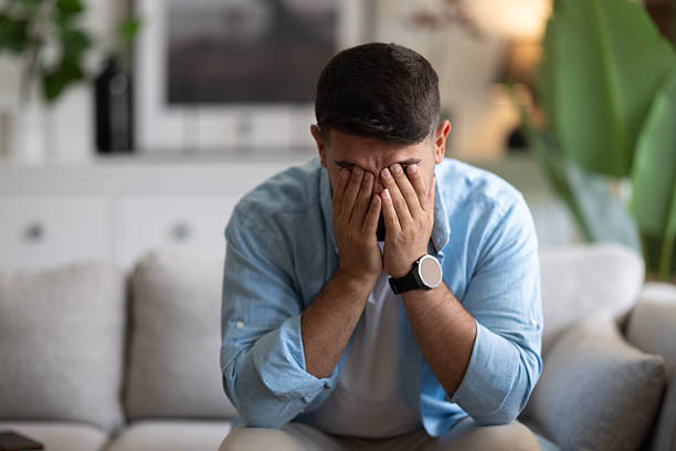 istock Man sitting alone at home looking sad and distraught 2237594467