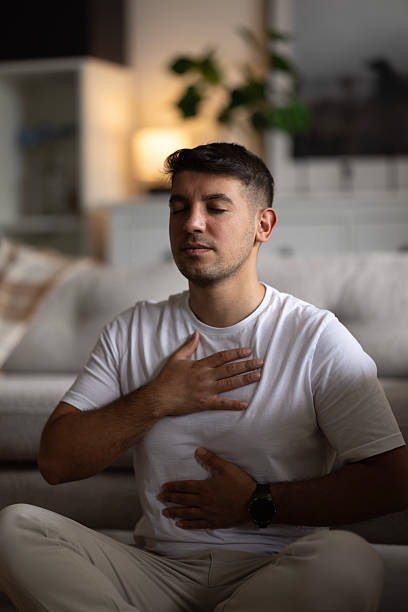 istock Young man meditating at home 2237594648