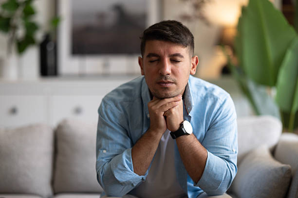 istock Thoughtful serious man sitting on sofa at home, lost in thoughts 2237598381