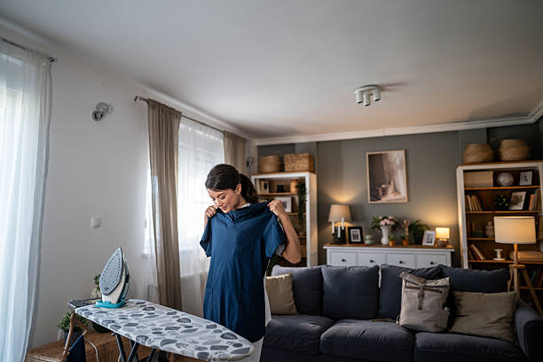 istock Young woman checking shirt before ironing at home 2237604996
