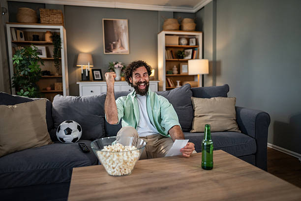 istock Man celebrating watching soccer game at home 2237606514