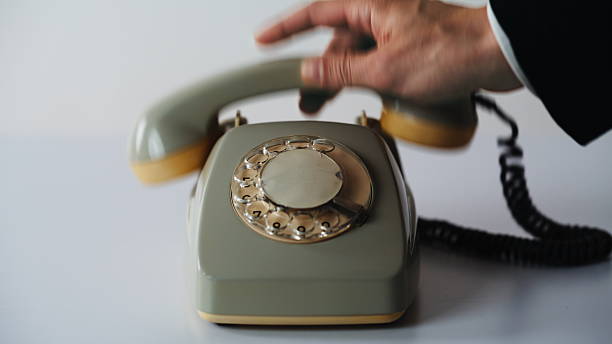 istock Hand picking up rotary telephone on white background closeup. Unrecognizable man 2237606577