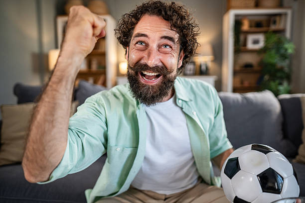 istock Man cheering soccer game watching at home 2237606590