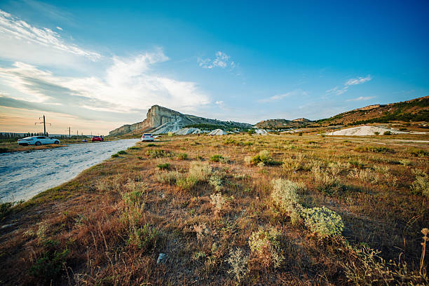 Scenic landscape showcasing the majestic White Rock mountain in Koktebel, Crimea, bathed in the warm glow of the setting sun