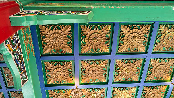 View upwards at a wooden pavilion roof with a repeating tile pattern and painted bright colors