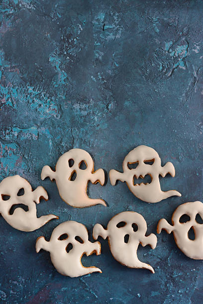 istock Image of copyspace, white iced ghost cookies / homemade halloween biscuits, spooky icing, scary 2237610791