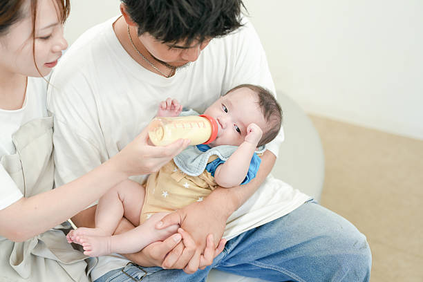 A man is feeding a baby with a bottle