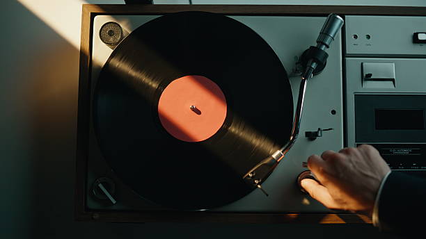 istock Hand turning off vinyl player in quiet apartment lit by evening light closeup. 2237613642