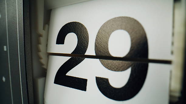 istock Flip clock changing panels closeup. Vintage flipclock showing black numbers 2237613901