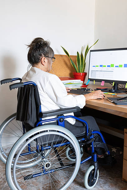 istock Woman working in office using computer and wheelchair 2237615844