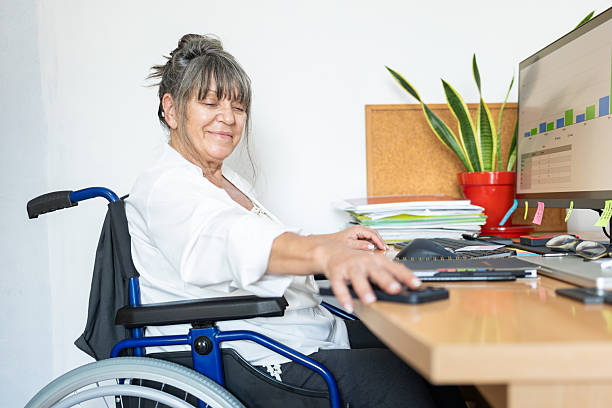 istock Woman in wheelchair working in office using phone 2237615963